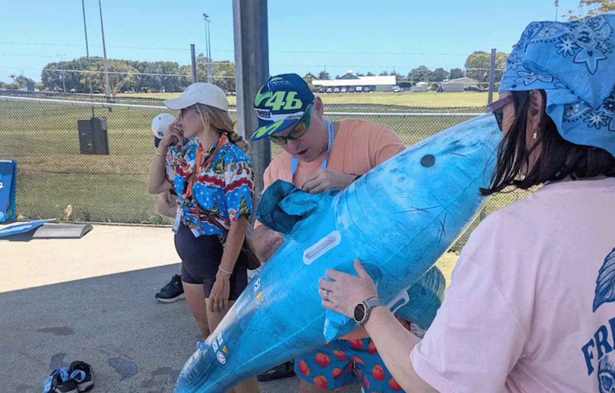 Teams blowing up pool toys before swimming relay laps in a Sunshine Coast Amazing Race
