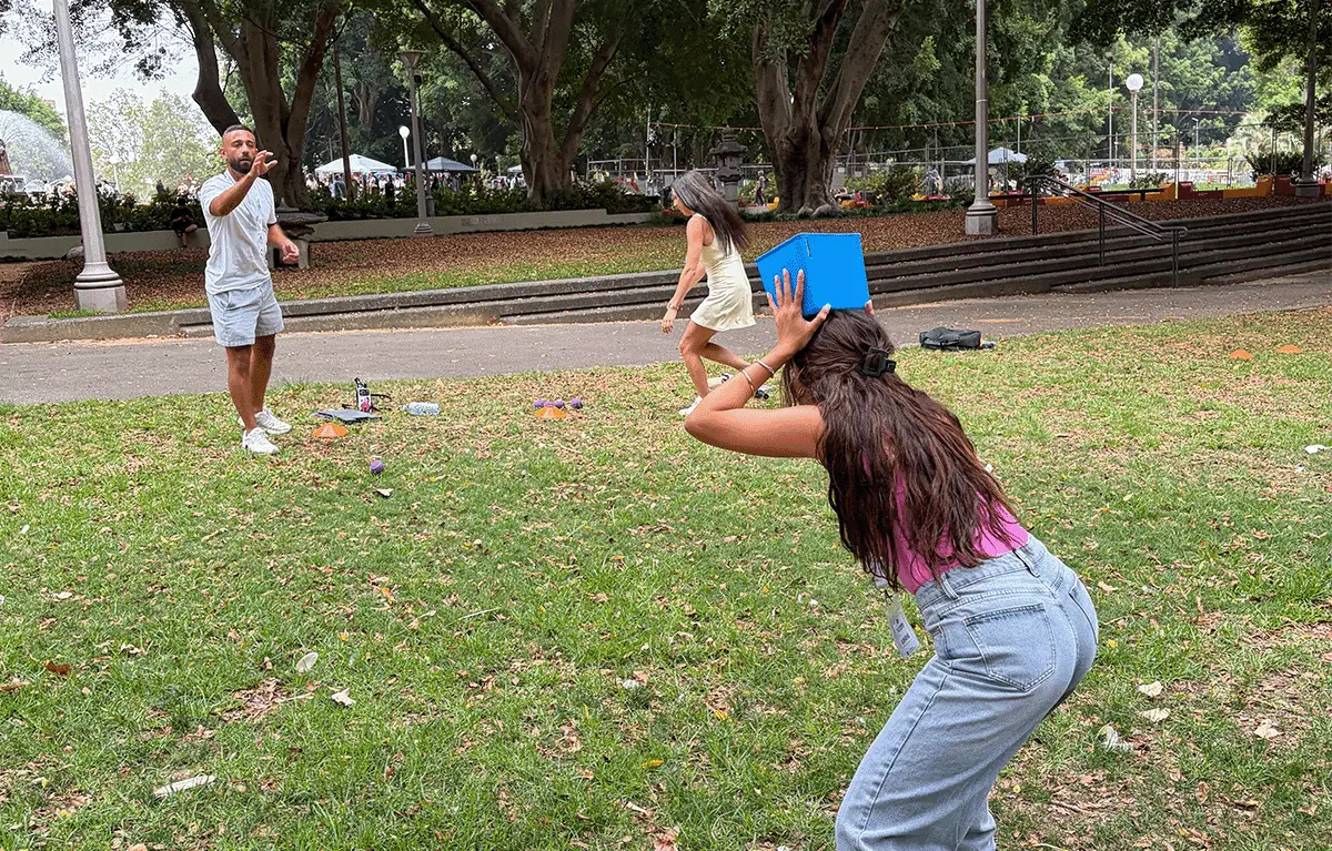 Friends working together on a bucket catch challenge during a Sydney Amazing Race