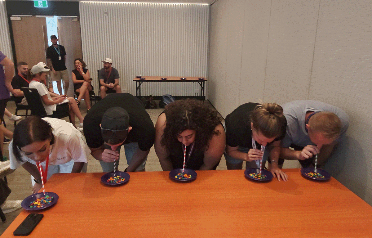 Fun corporate team building game show with teams competing in Minute to Win It challenges