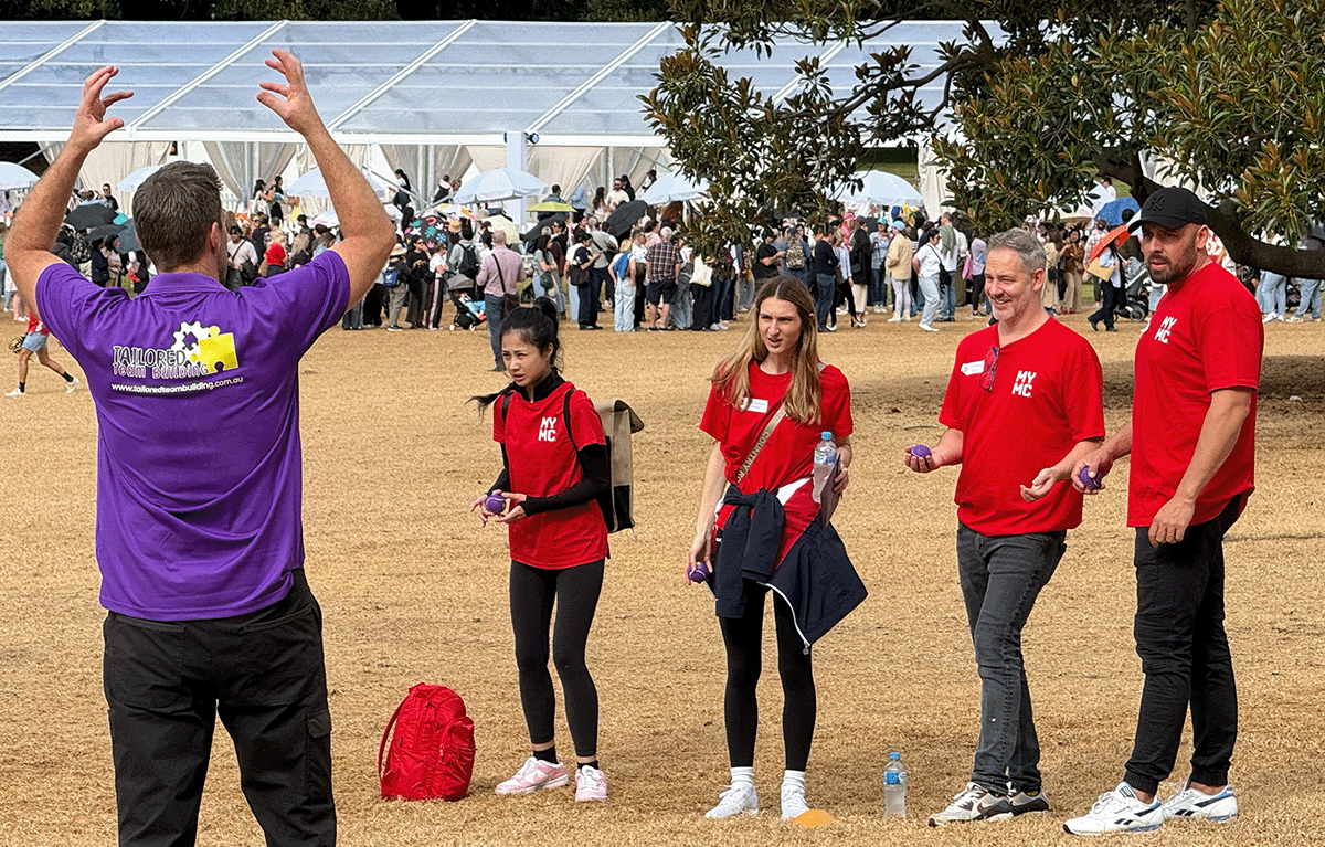 Corporate team laughing during outdoor team building activity in Sydney city