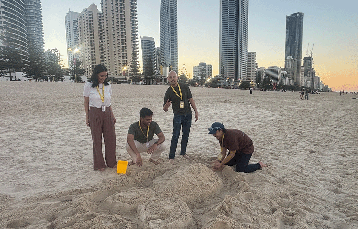 Team building participants constructing sandcastles during a Gold Coast Amazing Race.