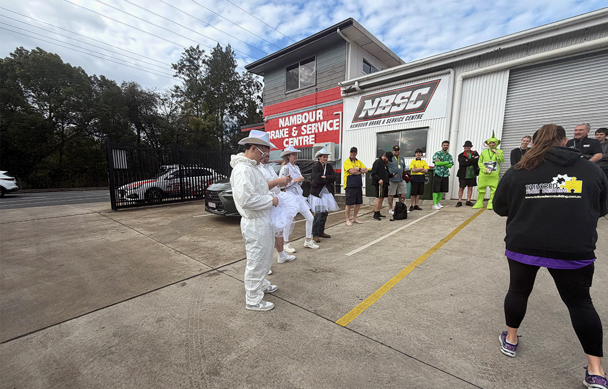 Corporate team celebrating after completing a checkpoint in a Driving Amazing Race on the Sunshine Coast.