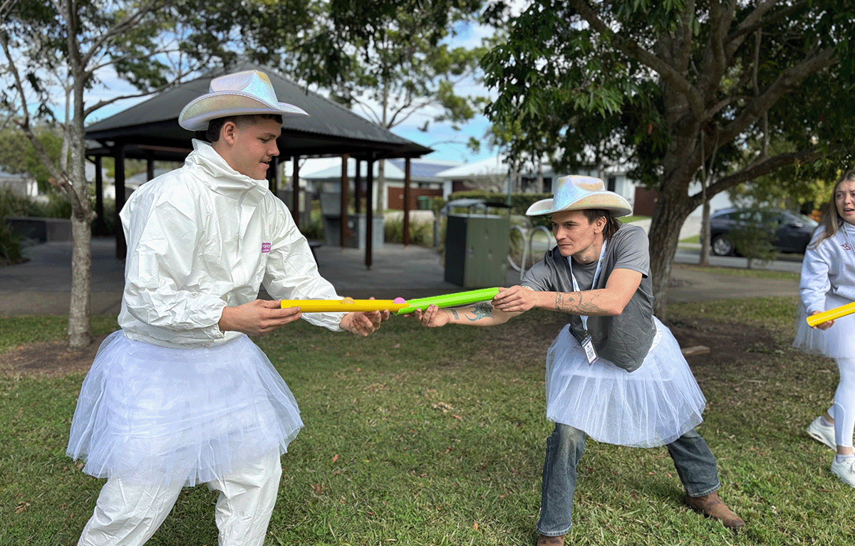 Corporate team working together on a pipeline challenge during an outdoor team building event in Nambour.